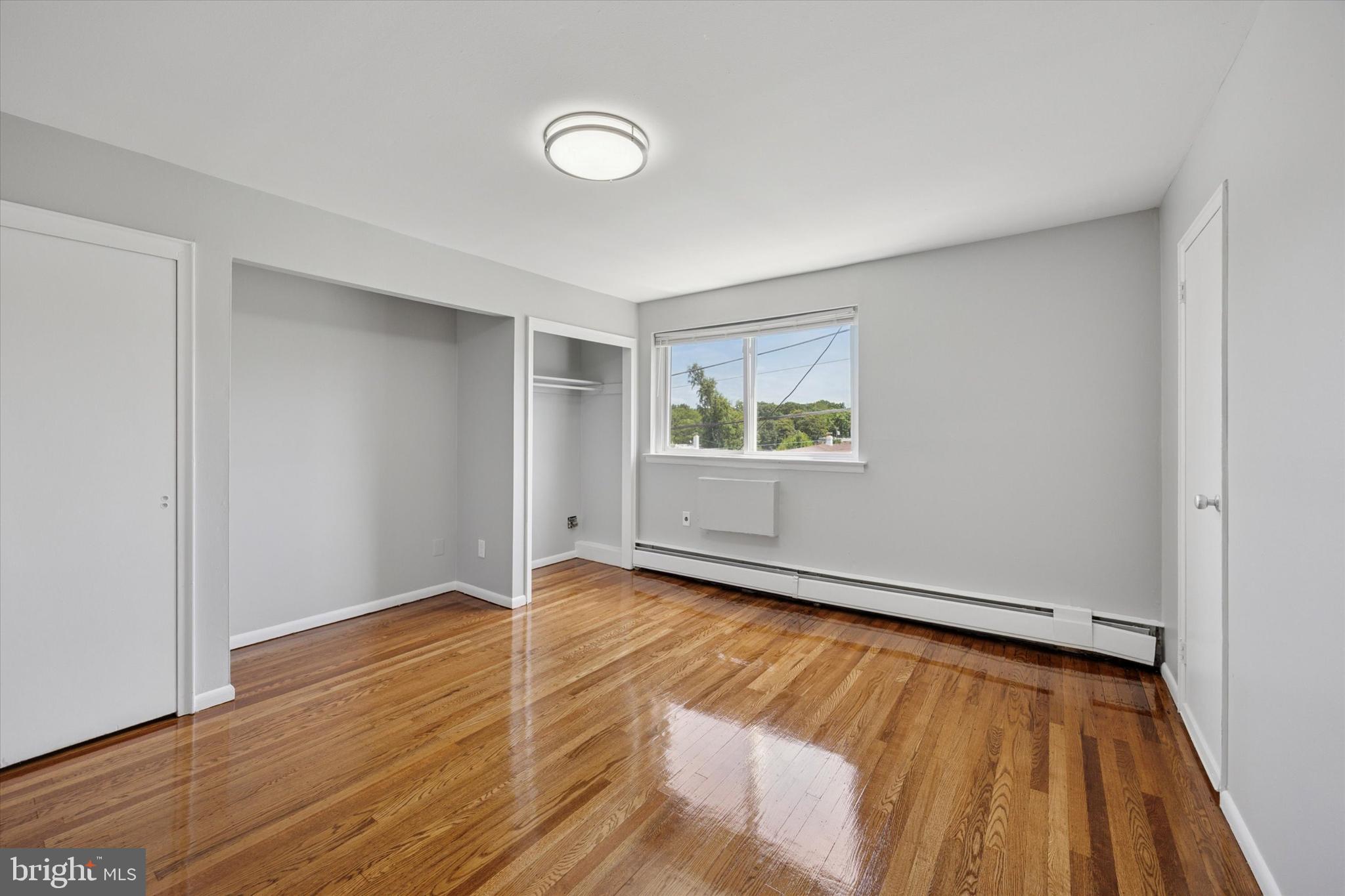 8410 Bustleton Avenue, Unit A 14 Philadelphia, PA 19152 - Photo 4 of 15 an empty room with wooden floor and windows