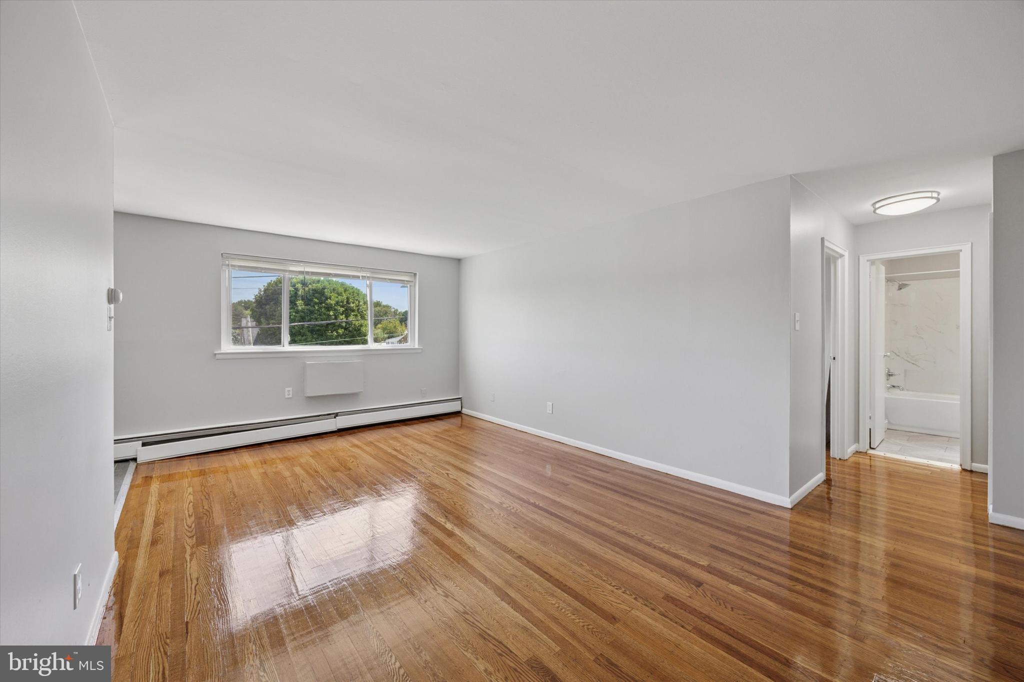 8410 Bustleton Avenue, Unit A 14 Philadelphia, PA 19152 - Photo 8 of 15 a view of an empty room with wooden floor and a window