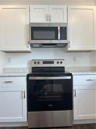 a kitchen with stainless steel appliances granite countertop a stove microwave and oven