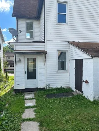 a view of a house with brick walls and a yard with plants