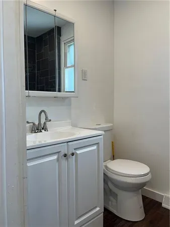 a bathroom with a toilet sink and mirror