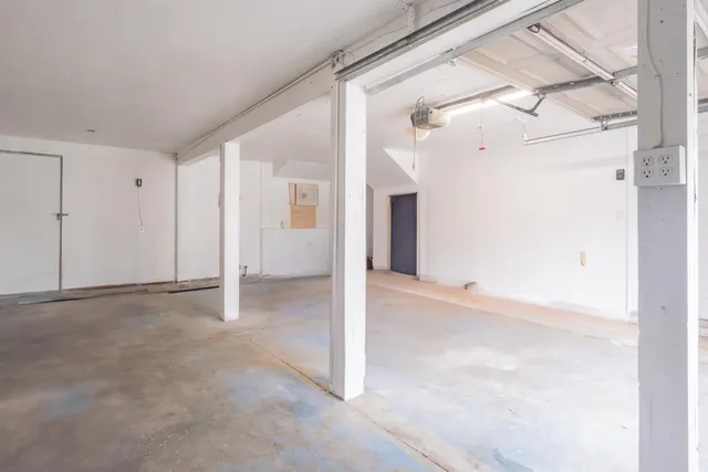 a view of staircase with white walls and white door