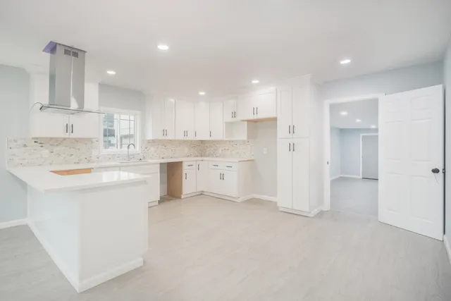 a kitchen with a sink white cabinets and stainless steel appliances