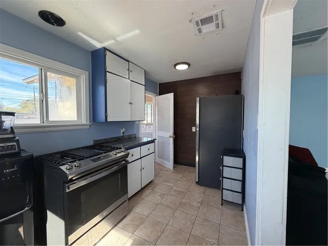 a kitchen with stainless steel appliances granite countertop a refrigerator and a stove top oven
