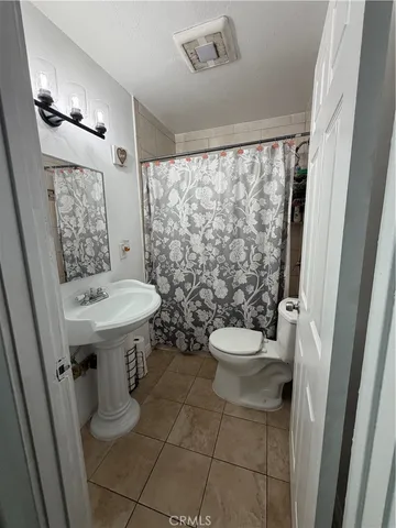a bathroom with a sink a toilet a mirror and shower