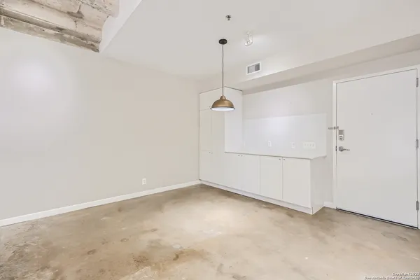 a view of a kitchen with a refrigerator and white cabinets