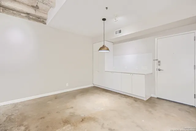 a view of a kitchen with a refrigerator and white cabinets
