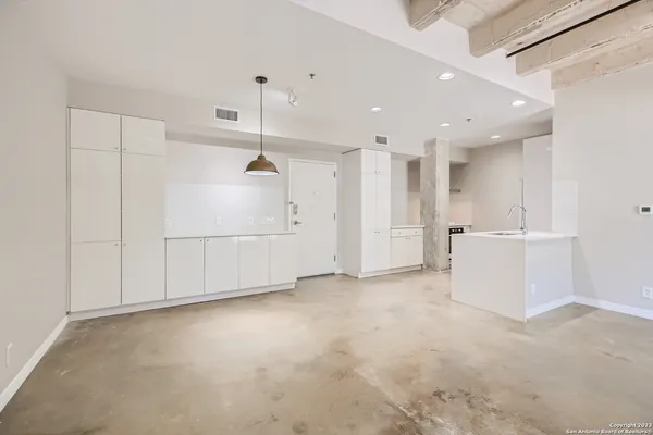 a view of a kitchen with refrigerator and white walls