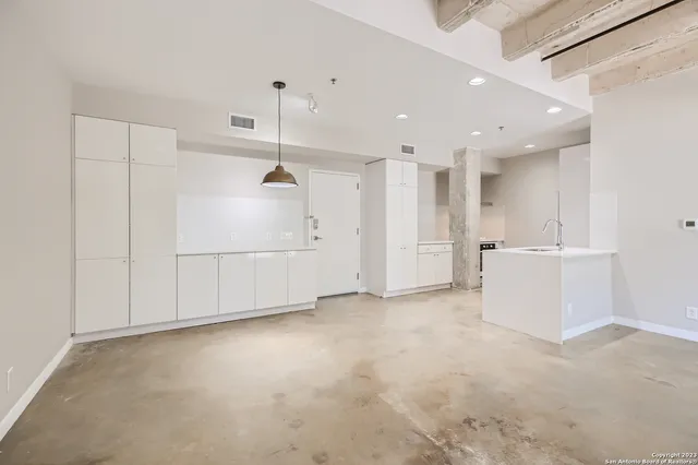 a view of a kitchen with refrigerator and white walls