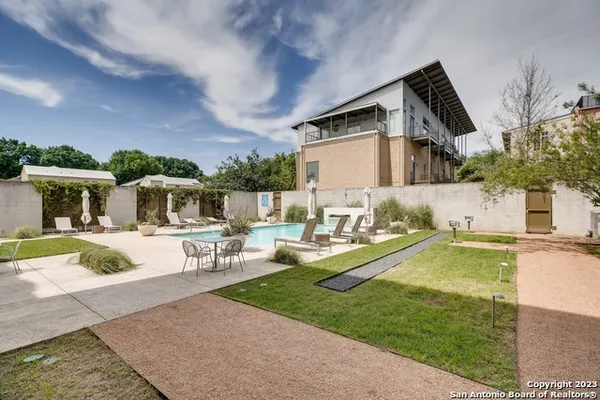 a swimming pool with outdoor seating and yard