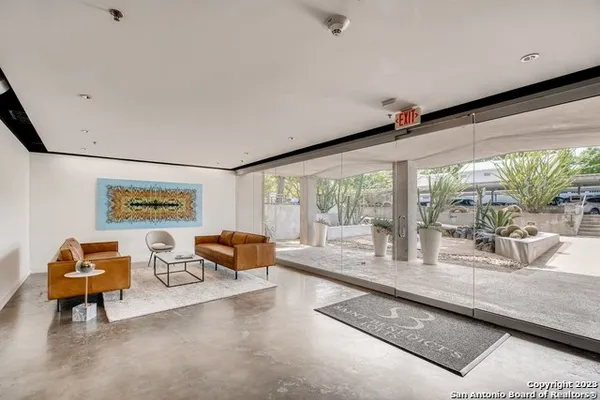 a living room with furniture and large windows