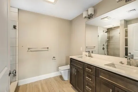 a bathroom with a double vanity sink toilet and shower