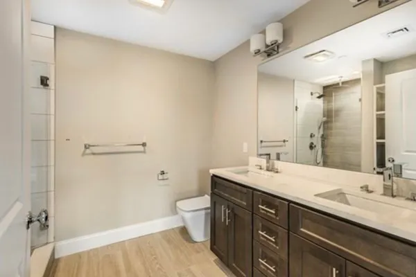 a bathroom with a double vanity sink toilet and shower