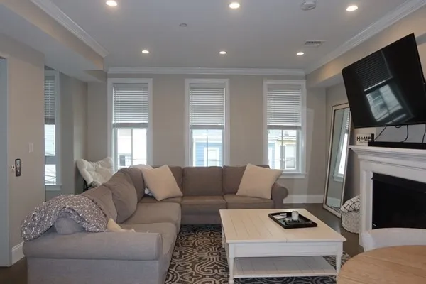 a living room with furniture a flat screen tv and a fireplace