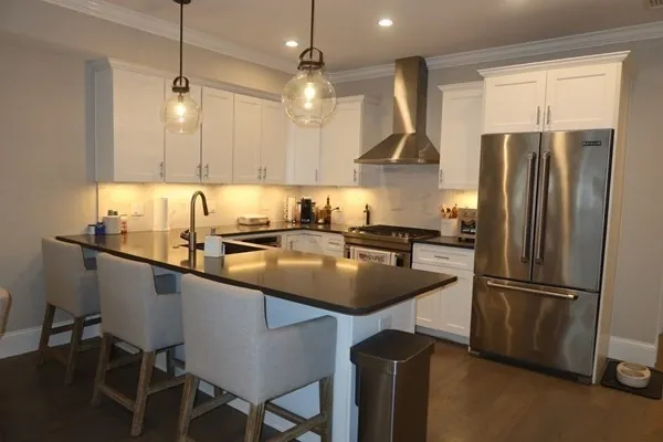 a kitchen with stainless steel appliances granite countertop a sink a stove and a refrigerator