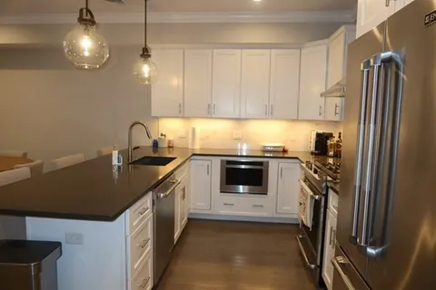 a kitchen with a sink a stove and cabinets