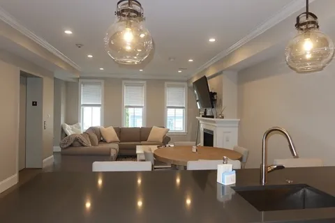 a large living room with furniture and a chandelier