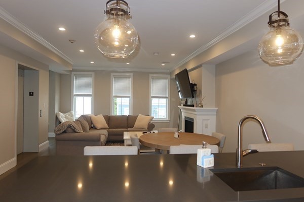 205 West 8th Street, Unit 4 Boston, MA 02127 - Photo 9 of 22 a large living room with furniture and a chandelier