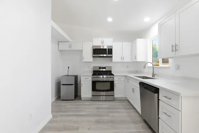 a kitchen with granite countertop a stove top oven sink and cabinets