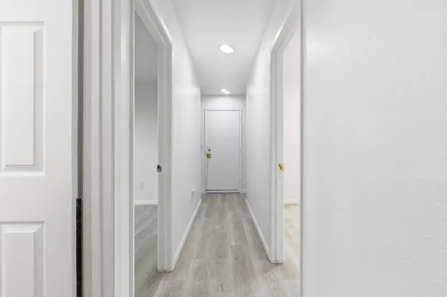 a view of a hallway with wooden floor