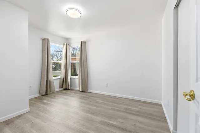 an empty room with closet and windows