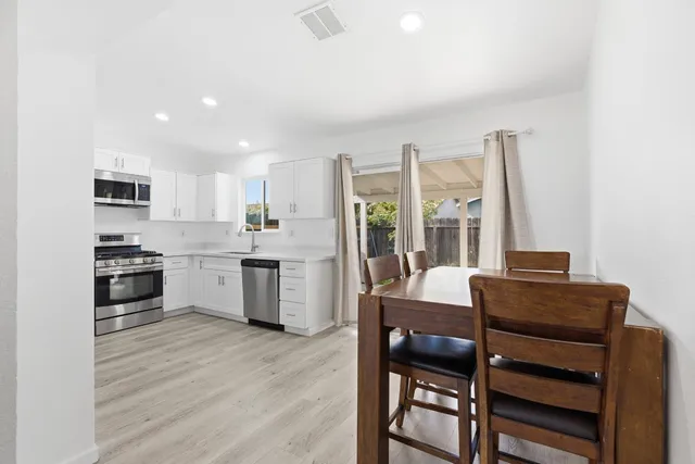 a kitchen with a table chairs refrigerator and cabinets