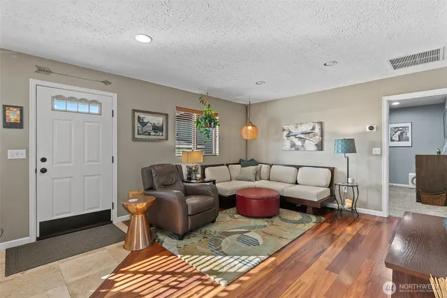 a living room with furniture and a wooden floor