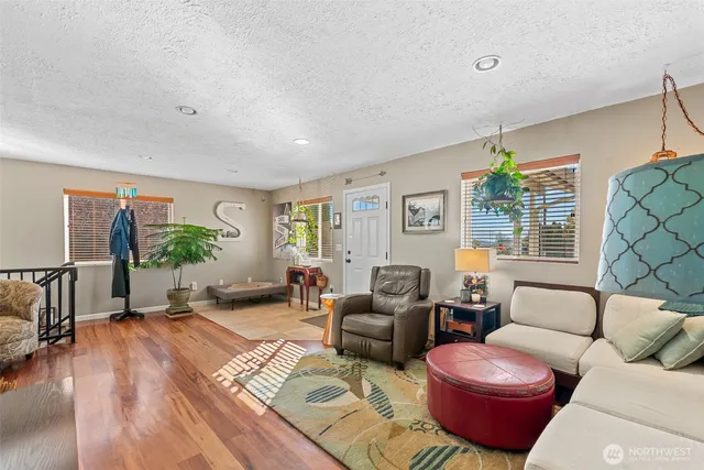 a living room with furniture a window and a wooden floor