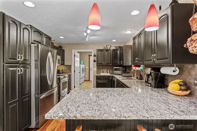 a kitchen with sink refrigerator and microwave