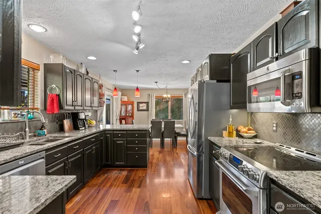 a kitchen with stainless steel appliances granite countertop a stove and a sink