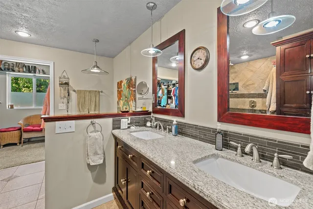 a bathroom with a granite countertop sink and a mirror