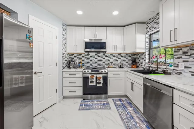 a kitchen with stainless steel appliances kitchen island granite countertop a sink stove and cabinets