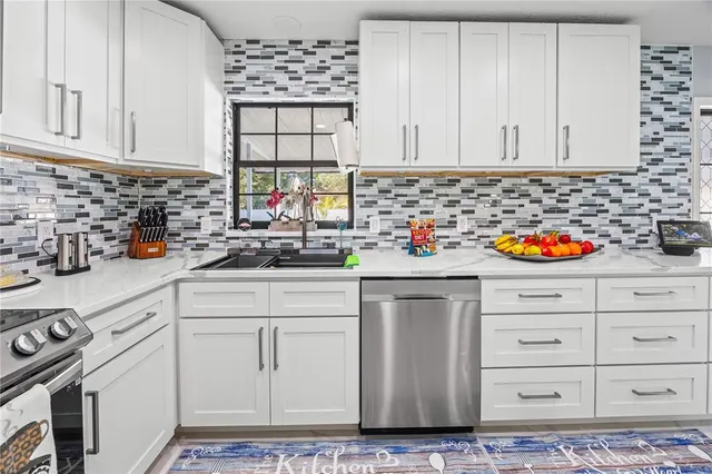 a kitchen with white cabinets and sink