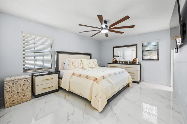 a bedroom with a large bed and a chandelier