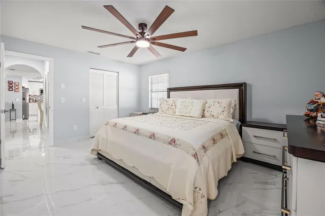 a bedroom with a large bed and a chandelier