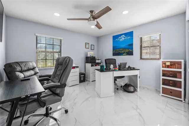 a work room with furniture a air conditioner and a window