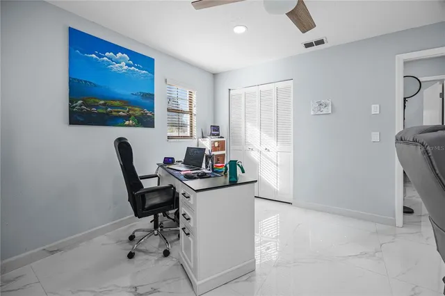 a view of a workspace with furniture and a window