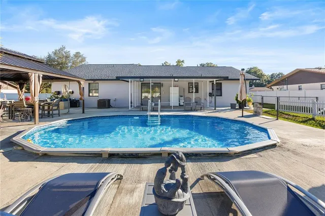 a view of a house with swimming pool and sitting area