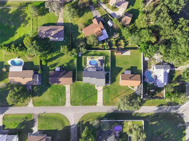 an aerial view of a house with a yard and outdoor seating