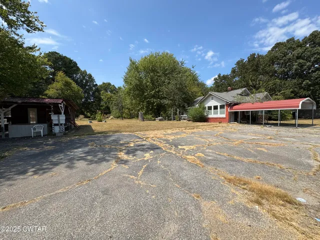 a front view of a house with a yard and trees