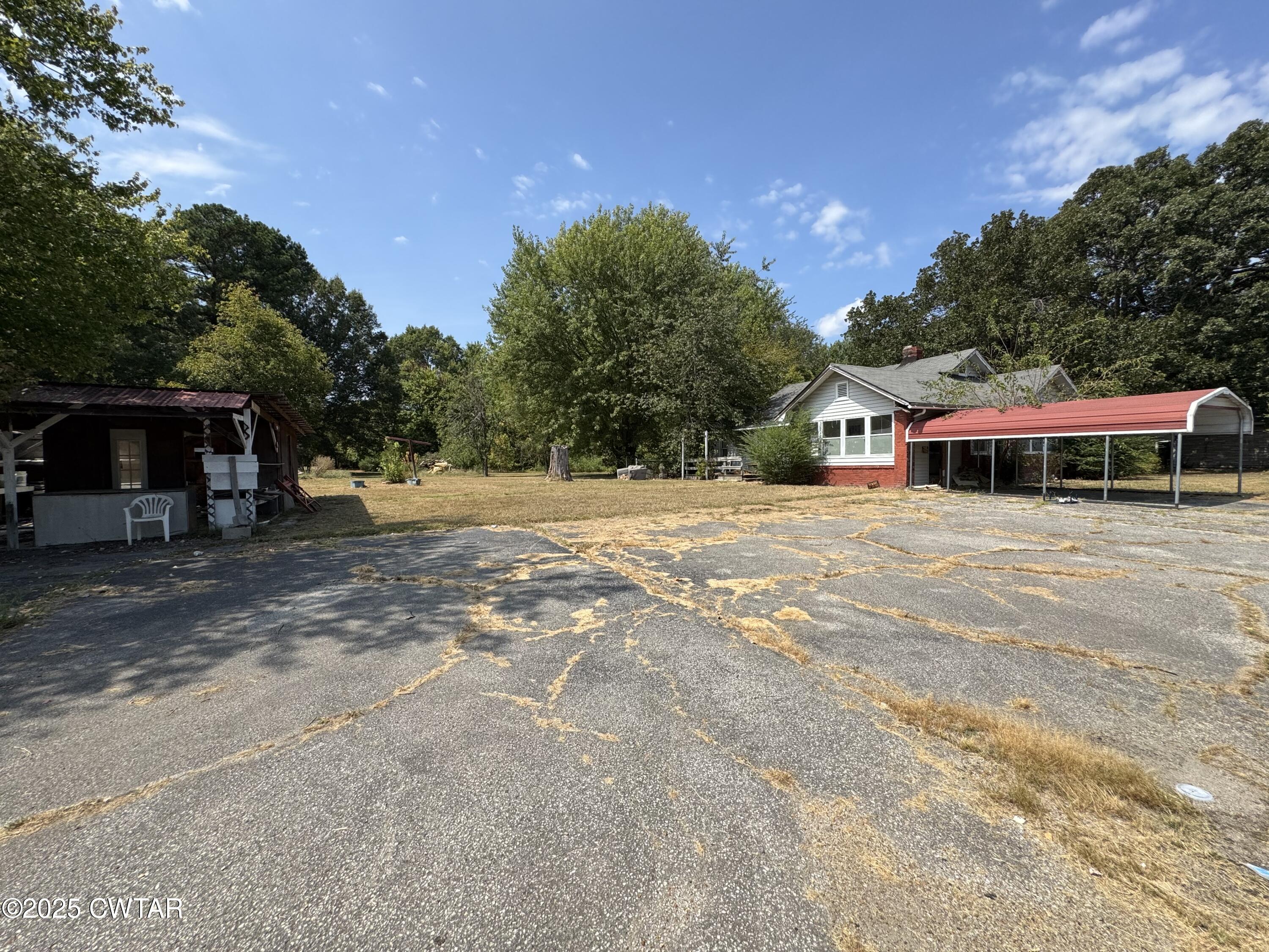 a front view of a house with a yard and trees