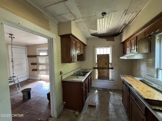 a kitchen with stainless steel appliances granite countertop sink stove refrigerator and cabinets