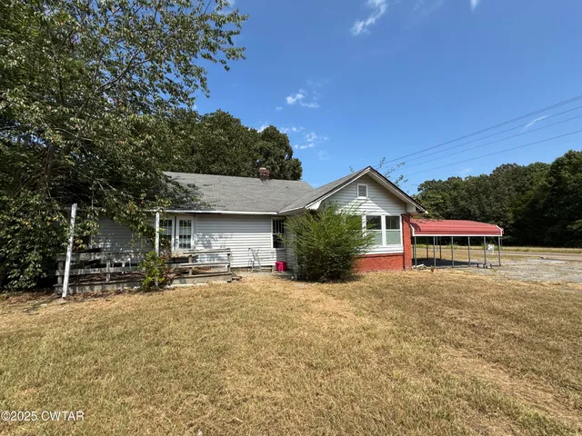 a view of a house with a yard and sitting area