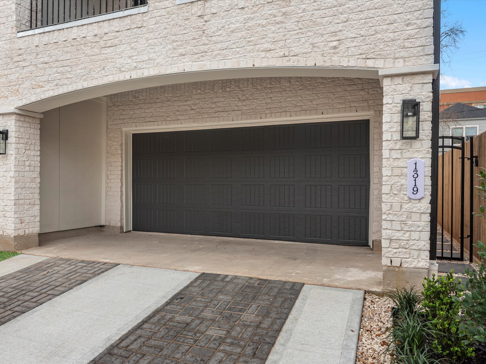 1319 West Bell Street Houston, TX 77019 - Photo 4 of 50 Modern townhomes with a clean, contemporary facade featuring three stories, balconies, and attached garages. The exterior is finished with light brick and dark garage doors. The property is set in a residential neighborhood with a mix of architectural styles.