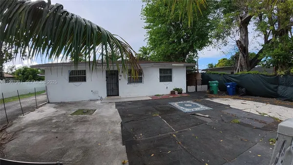 a front view of house with yard and trees around