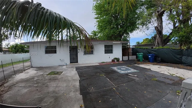 a front view of house with yard and trees around