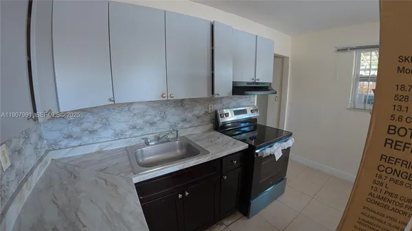 a kitchen with stainless steel appliances a stove a sink and a refrigerator