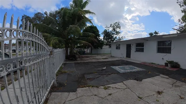a view of a house with backyard and trees