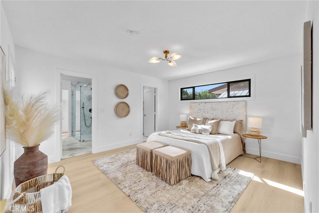 13682 Carroll Way Tustin, CA 92780 - Photo 38 of 51 a bedroom with a large bed and a chandelier