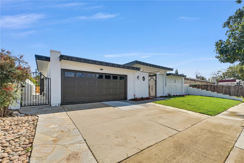 13682 Carroll Way Tustin, CA 92780 - Photo 8 of 51 a front view of a house with a yard and garage
